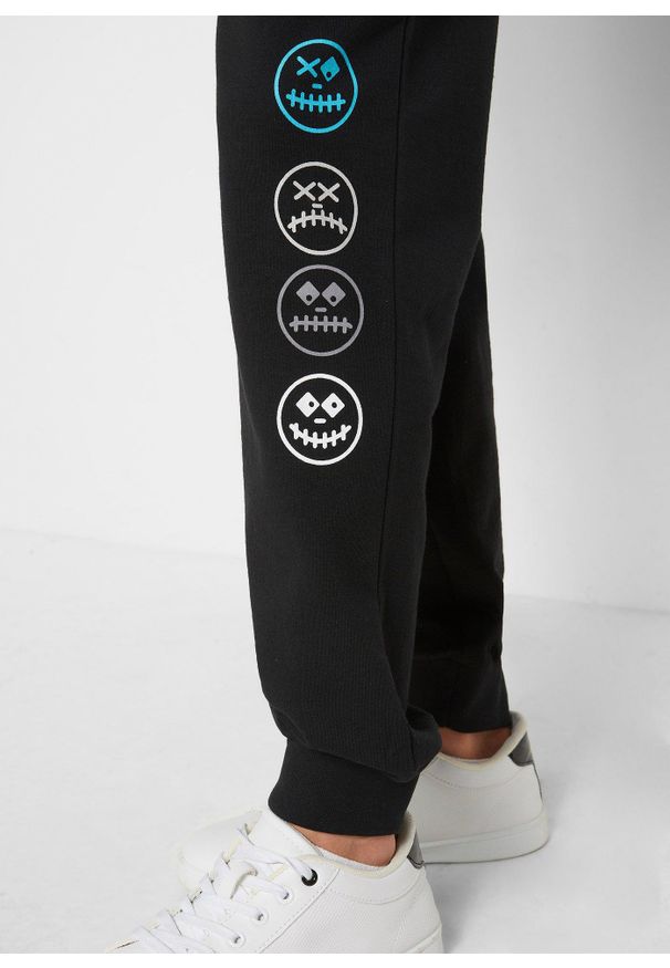 bonprix - Spodnie dresowe z miękkiej mieszanki bawełny. Kolor: czarny. Materiał: bawełna, dresówka. Wzór: nadruk