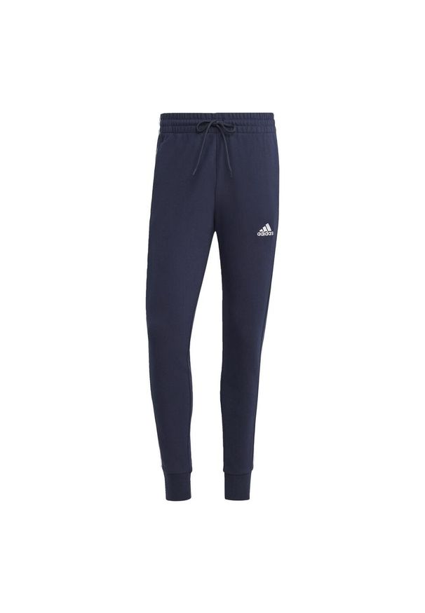Adidas - Spodnie dresowe męskie adidas Essentials French Terry Tapered Cuff 3-Stripes. Kolor: biały, czarny, niebieski, wielokolorowy. Materiał: dresówka