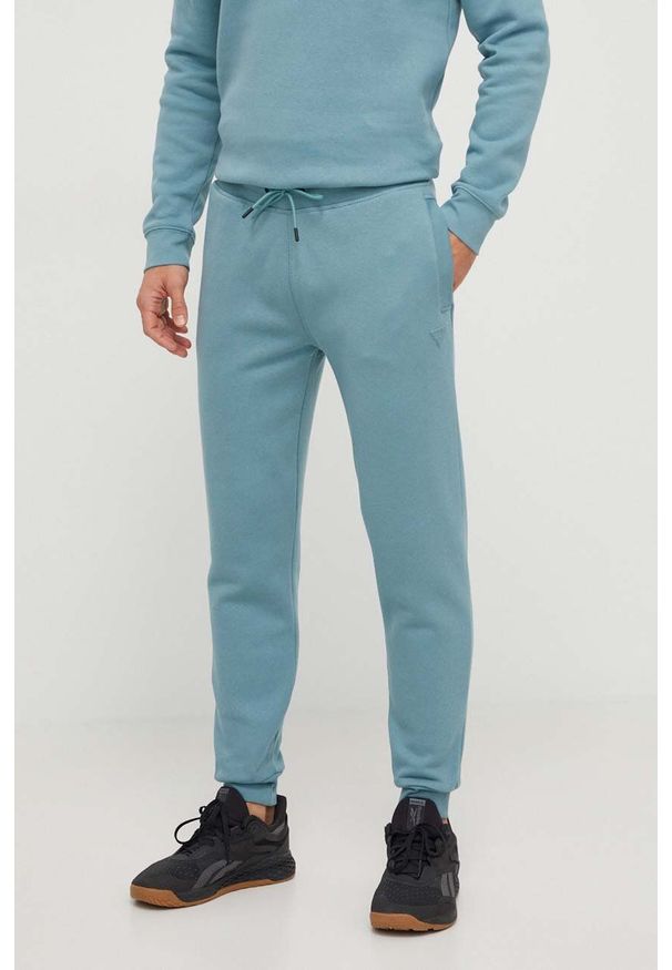 Guess spodnie dresowe kolor zielony melanżowe. Kolor: turkusowy. Materiał: dresówka. Wzór: melanż