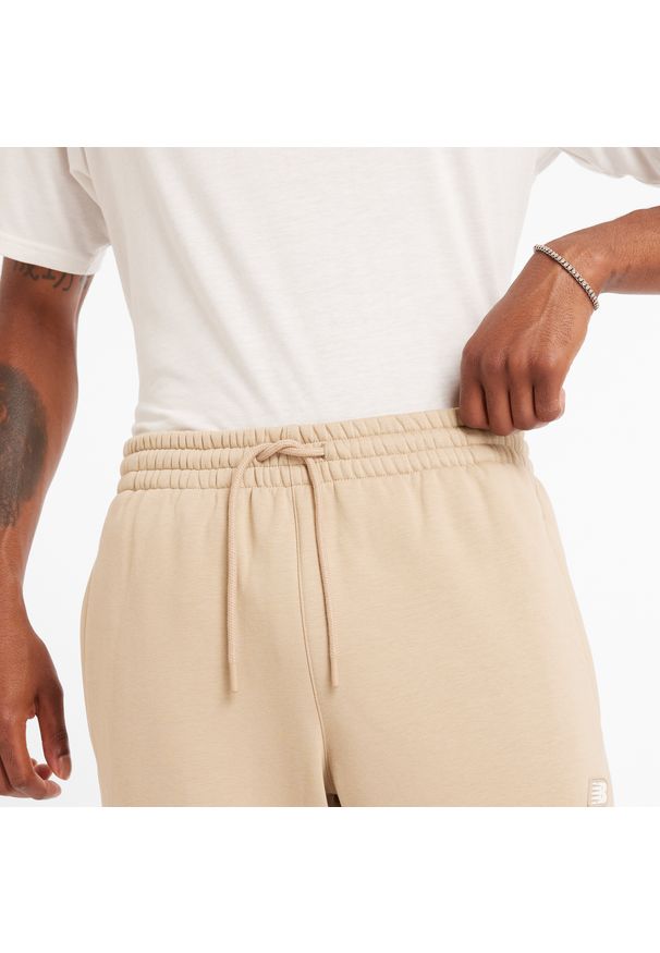 Spodnie męskie New Balance MP44587SNW – beżowe. Kolor: beżowy. Materiał: poliester, bawełna