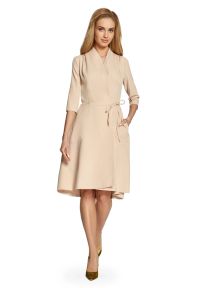 Sukienki.shop - Sukienka trapezowa kopertowa z paskiem i kieszeniami beżowa. Okazja: na co dzień, na spotkanie biznesowe, do pracy. Typ kołnierza: dekolt w kształcie V, dekolt kopertowy. Kolor: beżowy. Wzór: gładki. Typ sukienki: kopertowe, trapezowe. Materiał: tkanina, elastan. Sezon: wiosna, jesień, lato. Styl: casual, biznesowy, elegancki, klasyczny. Długość: midi #1