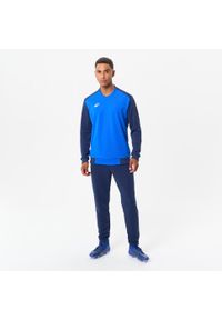 KIPSTA - Bluza piłkarska dla dorosłych Kipsta T100. Typ kołnierza: dekolt w kształcie V. Kolor: niebieski. Materiał: tkanina, materiał, elastan, poliester, prążkowany. Sport: piłka nożna
