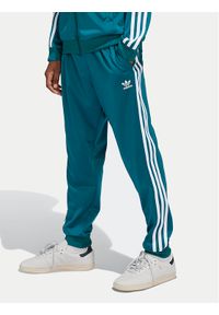 Adidas - adidas Spodnie dresowe adicolor SST IY7463 Turkusowy Regular Fit. Kolor: turkusowy. Materiał: syntetyk