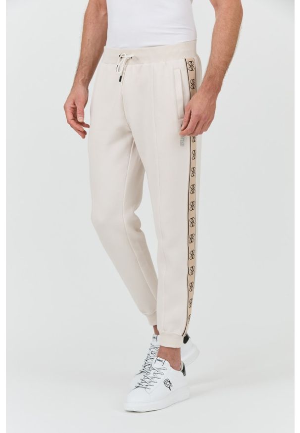 Guess - GUESS Beżowe spodnie Mickey Cuff Pant. Kolor: beżowy