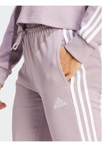 Adidas - adidas Spodnie dresowe Essentials 3-Stripes IR5379 Różowy Slim Fit. Kolor: różowy. Materiał: bawełna #6