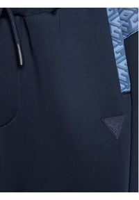 Guess Spodnie dresowe L3RQ15 JR06W Niebieski Relaxed Fit. Kolor: niebieski. Materiał: syntetyk