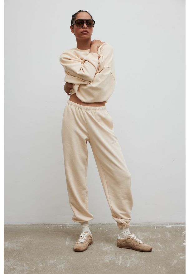 Marsala - Spodnie typu jogger z HAFTEM w kolorze BISQUIT - NEVIS-XL. Materiał: guma, bawełna, dzianina, poliester. Wzór: haft. Styl: elegancki
