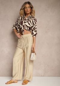 Renee - Beżowe Spodnie Typu Palazzo o Szerokim Kroju High Waist Ozdobione Wiązaniem Yaslevia. Okazja: na co dzień. Stan: podwyższony. Kolor: beżowy. Wzór: aplikacja. Styl: casual, elegancki