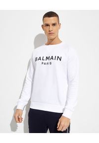Balmain - BALMAIN - Biała bluza z nadrukiem logo. Kolor: biały. Materiał: prążkowany, bawełna. Długość: długie. Wzór: nadruk. Styl: klasyczny