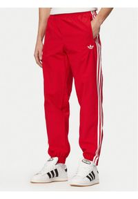Adidas - adidas Spodnie dresowe Firebird Woven KE1369 Czerwony Regular Fit. Kolor: czerwony. Materiał: syntetyk #1