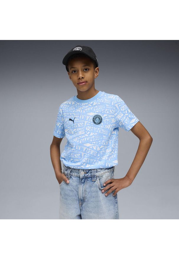 Puma - Młodzieżowa koszulka Manchester City FtblCulture z nadrukiem na całej. Kolor: niebieski, wielokolorowy, biały. Wzór: nadruk. Sport: piłka nożna