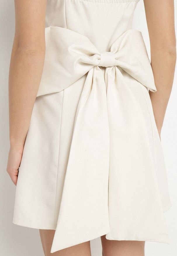 Born2be - Beżowa Rozkloszowana Sukienka na Ramiączkach Zdobiona Dużą Kokardą Lavvia. Okazja: na co dzień. Typ kołnierza: kokarda. Kolor: beżowy. Długość rękawa: na ramiączkach. Wzór: aplikacja. Typ sukienki: rozkloszowane. Styl: casual, elegancki