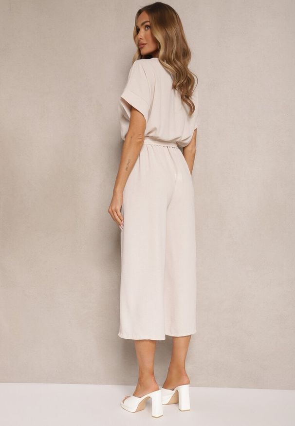 Renee - Beżowy Kopertowy Kombinezon o Prostym Kroju z Wiązanym Paskiem Tevenea. Okazja: na co dzień. Kolor: beżowy. Materiał: skóra. Długość rękawa: krótki rękaw. Długość: krótkie. Styl: klasyczny, casual, elegancki