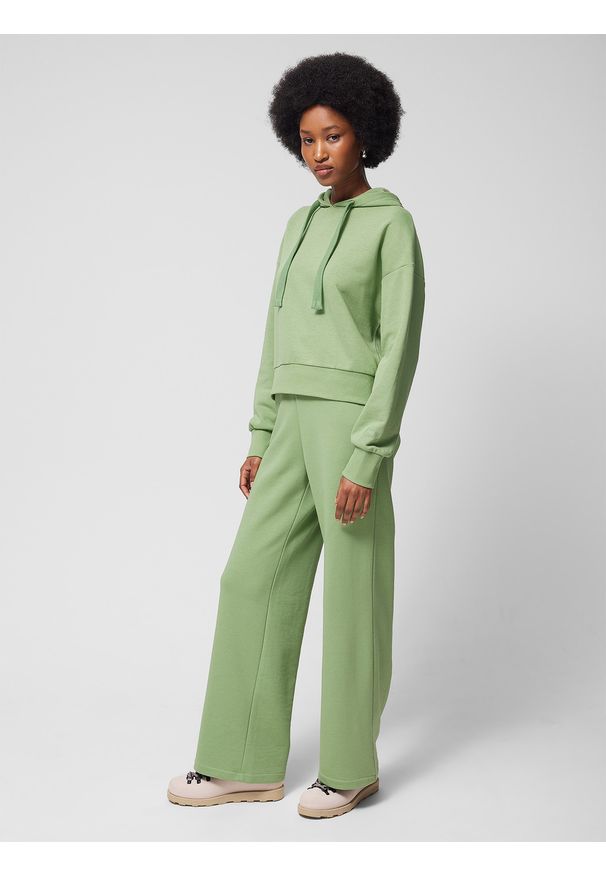 outhorn - Spodnie dresowe z szerokimi nogawkami damskie Outhorn - zielone. Stan: podwyższony. Kolor: zielony. Materiał: dresówka. Wzór: gładki, ze splotem