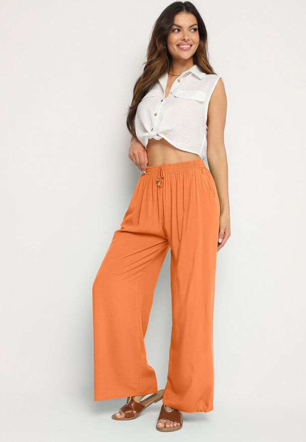 Born2be - Pomarańczowe Gładkie Spodnie z Gumką w Pasie i Szerokimi Nogawkami Alathera. Kolor: pomarańczowy. Wzór: gładki. Sezon: lato