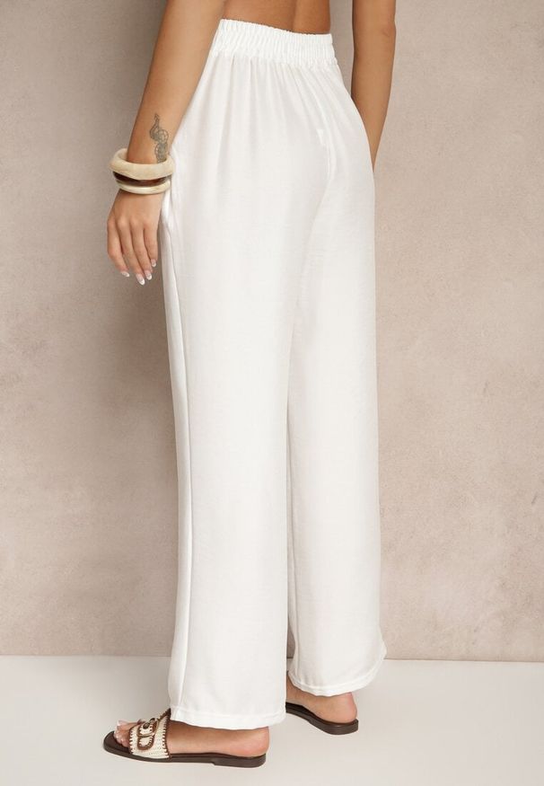 Renee - Jasnobeżowe Spodnie z Szeroką Nogawką i Gumką w Talii Zdobione Wiązaniem Mireniela. Okazja: na co dzień. Stan: podwyższony. Kolor: beżowy. Wzór: aplikacja. Styl: casual, elegancki