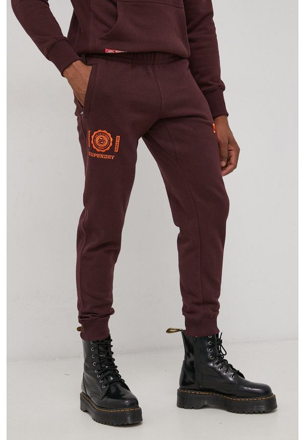 Superdry Spodnie bawełniane męskie kolor bordowy z aplikacją. Kolor: czerwony. Materiał: bawełna. Wzór: aplikacja