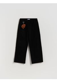 Reserved - Spodnie z brelokiem - czarny. Kolor: czarny. Materiał: tkanina, bawełna