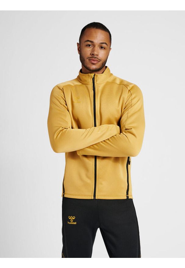 Bluza dresowa zapinana na zamek błyskawiczny Hummel Cima XK. Kolor: żółty, wielokolorowy, beżowy. Materiał: dresówka. Wzór: nadruk