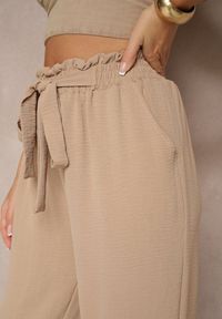 Renee - Ciemnobeżowe Spodnie High Waist Ozdobione Wiązanym Paskiem Araleira. Okazja: na co dzień, na spacer. Stan: podwyższony. Kolor: beżowy. Materiał: jedwab. Długość: długie. Wzór: aplikacja. Sezon: wiosna. Styl: casual
