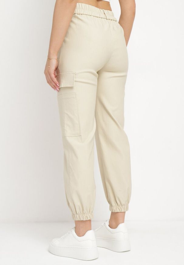 Born2be - Jasnobeżowe Spodnie Bojówki z Gumka w Pasie i na Dole przy Nogawkach Ozdobione Kieszenią z Klapą Veralie. Okazja: na co dzień. Kolor: beżowy. Materiał: bawełna. Wzór: aplikacja. Styl: militarny, casual, elegancki, klasyczny
