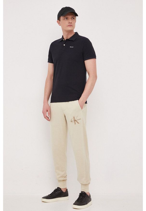 Calvin Klein Jeans spodnie dresowe bawełniane kolor beżowy gładkie. Kolor: beżowy. Materiał: bawełna, dresówka. Wzór: gładki