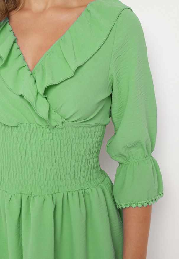 Born2be - Zielona Sukienka z Kopertowym Dekoltem i Gumką w Pasie Ozdobiona Falbanką Tesalie. Okazja: na co dzień. Typ kołnierza: kołnierz z falbankami, dekolt kopertowy. Kolor: zielony. Wzór: aplikacja. Sezon: wiosna, lato. Typ sukienki: kopertowe. Styl: elegancki, casual