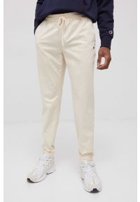 Champion spodnie męskie kolor beżowy joggery. Kolor: beżowy. Materiał: włókno, tkanina