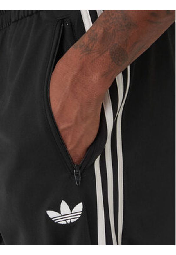 Adidas - adidas Spodnie dresowe Firebird KD8315 Czarny Loose Fit. Kolor: czarny. Materiał: syntetyk