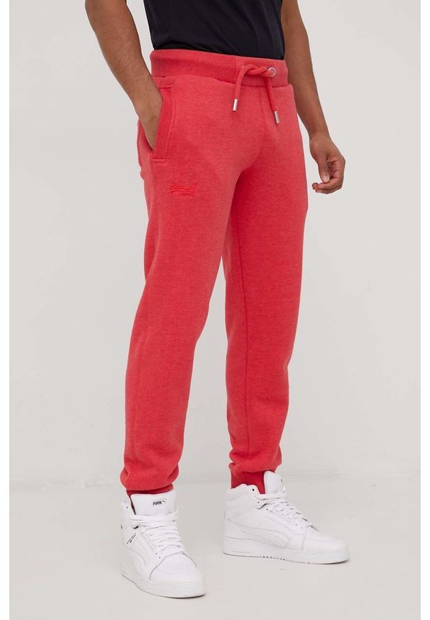 Superdry spodnie dresowe męskie kolor czerwony melanżowe. Kolor: czerwony. Materiał: dresówka. Wzór: melanż