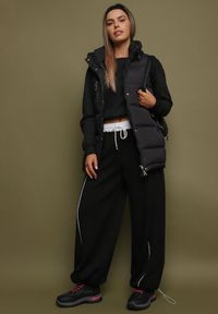 Born2be - Czarna Kamizelka Pikowana z Ozdobnym Suwakiem z Kapturem Fortisse. Okazja: na co dzień, na spotkanie biznesowe. Typ kołnierza: kaptur. Kolor: czarny. Styl: casual, elegancki, biznesowy, klasyczny #9