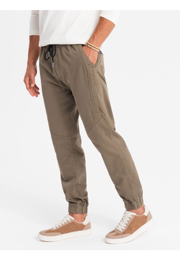 Ombre Clothing - Dzianinowe męskie spodnie joggery z ozdobną plisą – ciemnobrązowe V2. Okazja: na co dzień. Kolor: brązowy. Materiał: dzianina. Długość: długie. Wzór: jednolity, aplikacja. Styl: casual