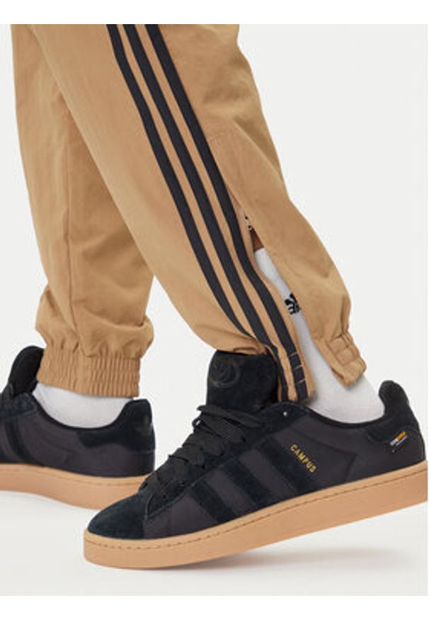 Adidas - adidas Spodnie dresowe adicolor Woven Firebird JY1339 Beżowy Regular Fit. Kolor: beżowy. Materiał: syntetyk
