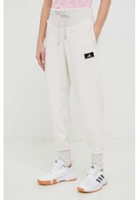 Adidas - adidas spodnie dresowe damskie kolor beżowy. Kolor: beżowy. Materiał: dresówka #1