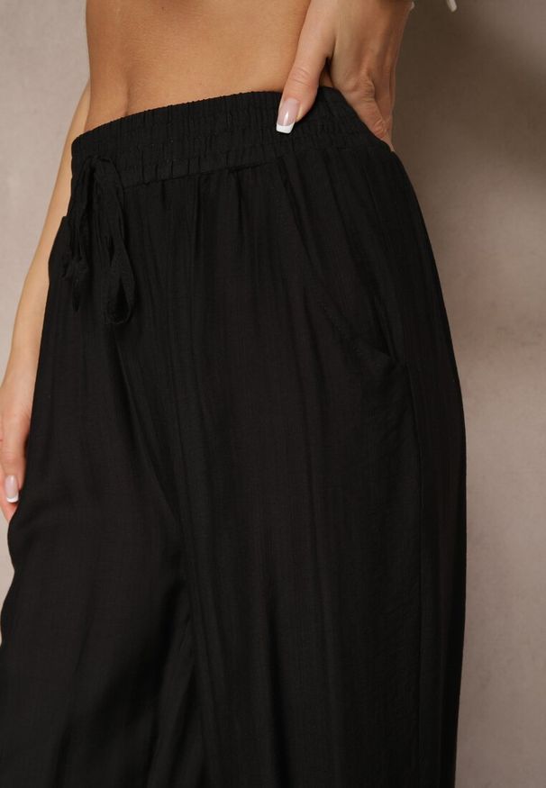 Renee - Czarne Spodnie Typu Palazzo o Szerokim Kroju High Waist Ozdobione Wiązaniem Yaslevia. Okazja: na co dzień. Stan: podwyższony. Kolor: czarny. Wzór: aplikacja. Styl: elegancki, casual