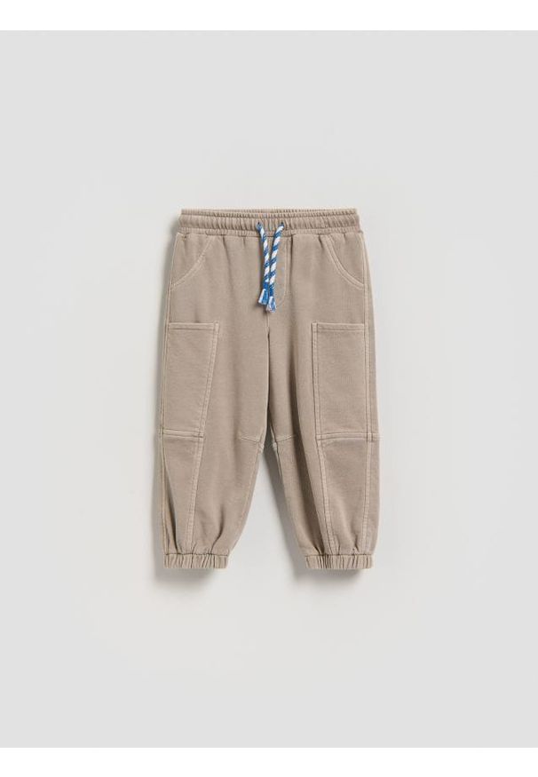 Reserved - Dresowe spodnie oversize - beżowy. Kolor: beżowy. Materiał: dresówka
