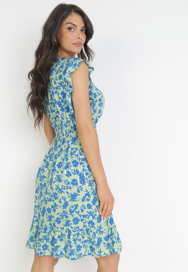 Born2be - Jasnozielona Rozkloszowana Sukienka z Wiskozy Ozdobiona Metalicznym Nadrukiem Elulaia. Typ kołnierza: kołnierz z falbankami. Kolor: zielony. Materiał: wiskoza. Wzór: nadruk, aplikacja. Typ sukienki: kopertowe