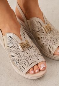 Born2be - Złote Skórzane Sandały na Koturnie z Perforacją i Metaliczną Aplikacją Zaehiesh. Okazja: na co dzień. Zapięcie: pasek. Kolor: złoty. Wzór: aplikacja. Materiał: skóra. Sezon: lato. Obcas: na koturnie. Styl: klasyczny, casual. Wysokość obcasa: średni #3