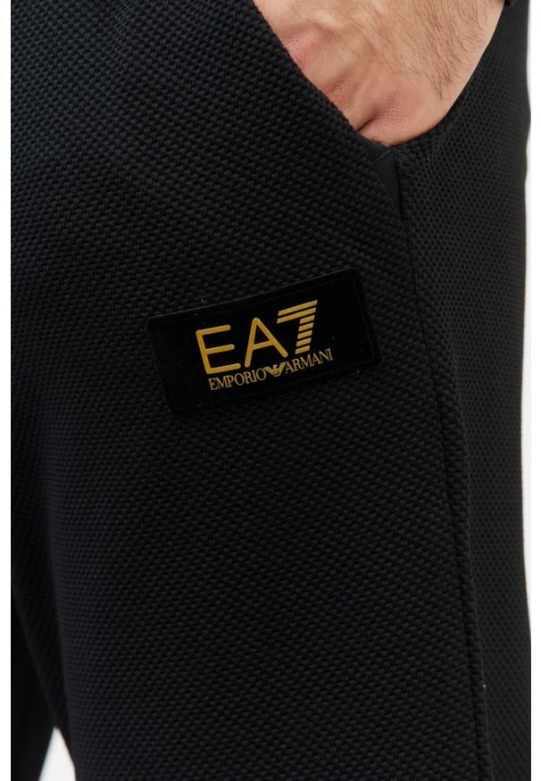 EA7 Emporio Armani - EA7 Czarne spodnie dresowe o ciekawej fakturze. Kolor: czarny. Materiał: dresówka. Wzór: aplikacja