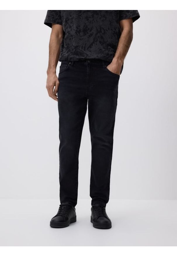 Reserved - Jeansy carrot slim z efektem sprania - czarny. Kolor: czarny