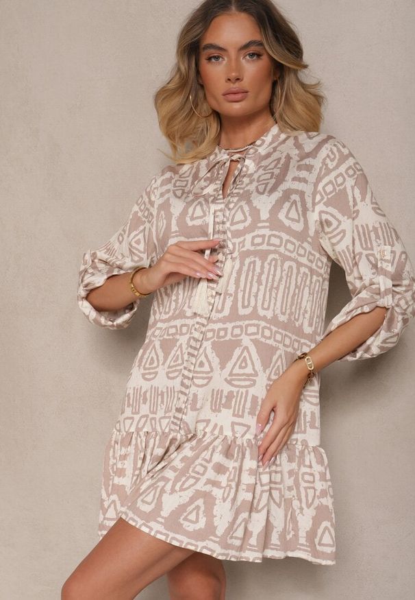 Renee - Beżowa Rozkloszowana Sukienka z Wiskozy w Etniczny Print z Wiązaniem z Frędzlami Ravpio. Typ kołnierza: dekolt w kształcie V. Kolor: beżowy. Materiał: wiskoza. Długość rękawa: długi rękaw. Wzór: nadruk. Styl: elegancki
