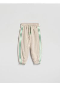 Reserved - Dresowe spodnie z lampasem - beżowy. Kolor: beżowy. Materiał: dresówka #1