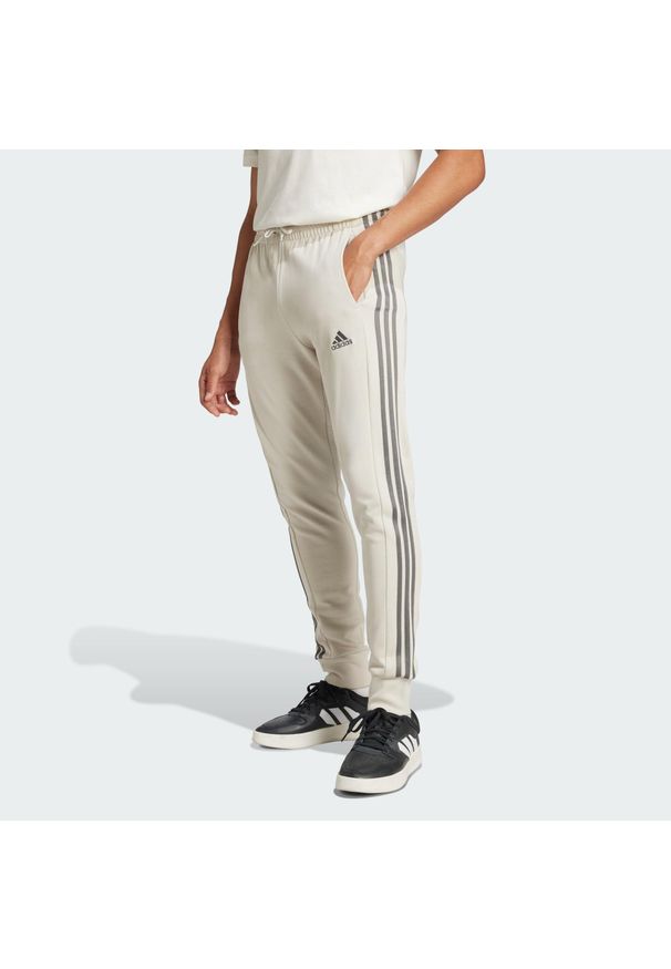 Adidas - Essentials French Terry Tapered Cuff 3-Stripes Pants. Kolor: zielony, wielokolorowy, szary. Materiał: dresówka