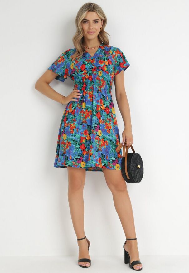 Born2be - Niebieska Sukienka Mini z Szeroką Gumką w Talii i Kopertowym Dekoltem Nevun. Typ kołnierza: dekolt kopertowy. Kolor: niebieski. Materiał: wiskoza. Wzór: kolorowy, aplikacja, kwiaty. Sezon: lato. Typ sukienki: kopertowe. Długość: mini