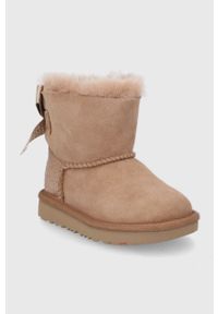 Ugg - UGG Śniegowce zamszowe dziecięce Mini Bailey Bow Glitz. Nosek buta: okrągły. Kolor: brązowy. Materiał: zamsz. Szerokość cholewki: normalna