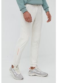 Under Armour spodnie dresowe 1366179 męskie kolor beżowy joggery. Kolor: beżowy. Materiał: dresówka #1