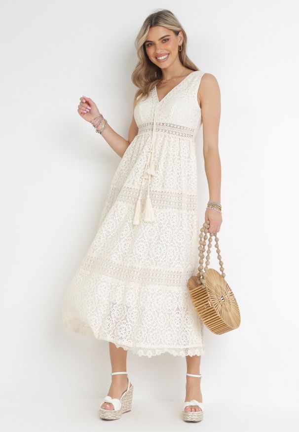 Born2be - Beżowa Koronkowa Sukienka Maxi z Głębokim Dekoltem i Ozdobnym Wiązaniem Nohia. Kolor: beżowy. Materiał: koronka. Długość rękawa: bez rękawów. Wzór: ażurowy. Sezon: wiosna, lato. Długość: maxi