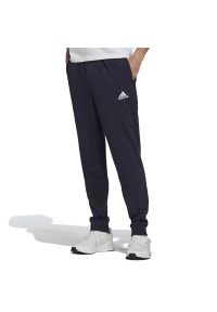 Adidas - Spodnie dresowe adidas Essentials Fleece Regular Fit Tapered Cuff H33664 - granatowe. Kolor: niebieski. Materiał: dresówka