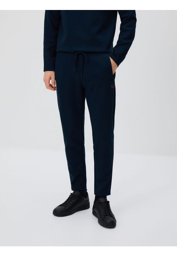 Reserved - Spodnie dresowe slim - granatowy. Kolor: niebieski. Materiał: dresówka