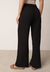 Born2be - Czarne Szerokie Spodnie z Teksturalnej Tkaniny z Wiązaniem w Pasie Agatia. Okazja: do pracy, na co dzień, na spacer. Stan: podwyższony. Kolor: czarny. Materiał: tkanina. Długość: długie. Styl: wakacyjny, casual #7